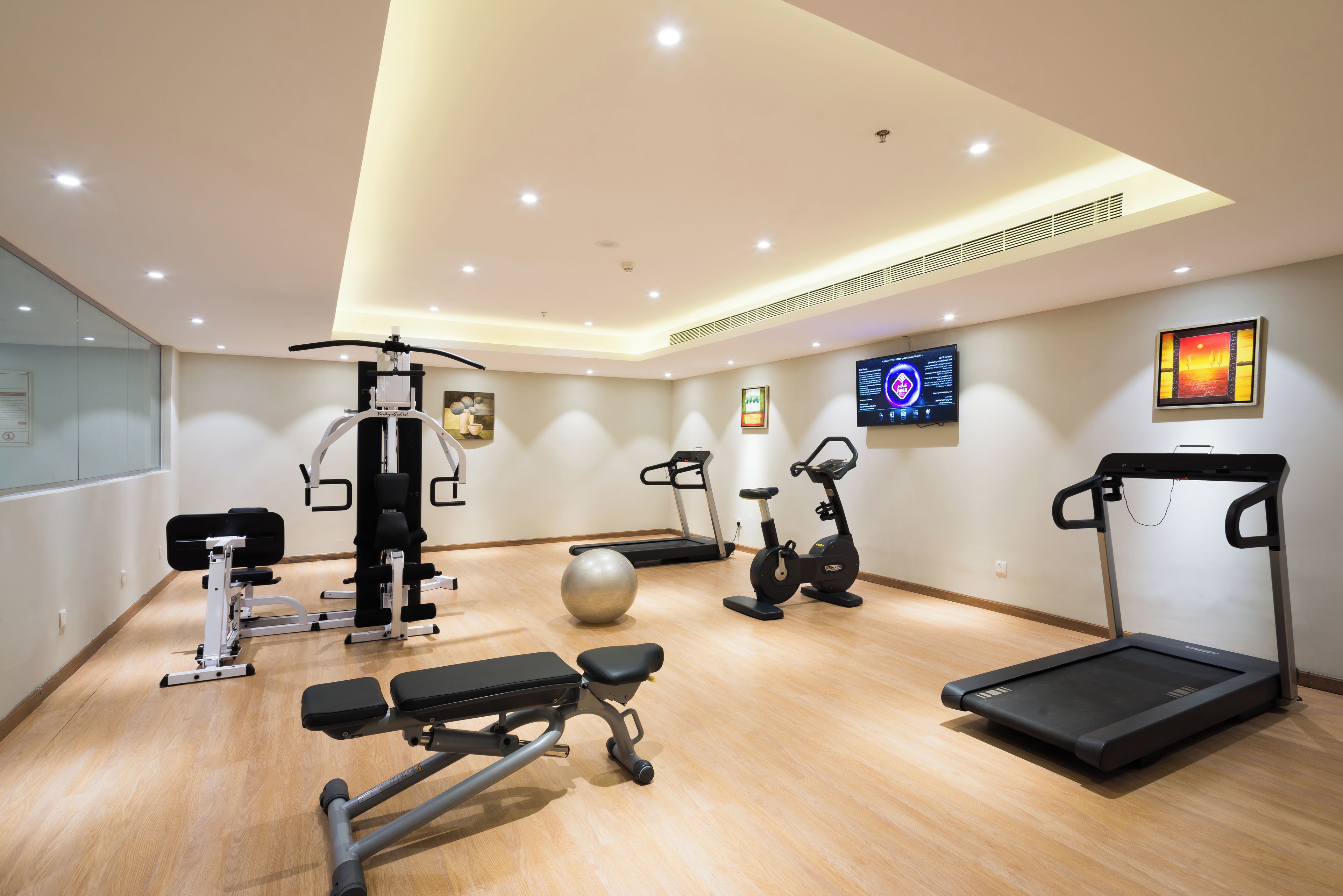 A gym with various exercise equipment including a treadmill, stationary bike, and weight machines.