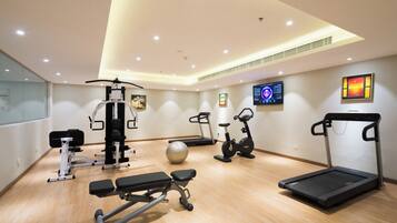 A gym with various exercise equipment including a treadmill, stationary bike, and weight machines.
