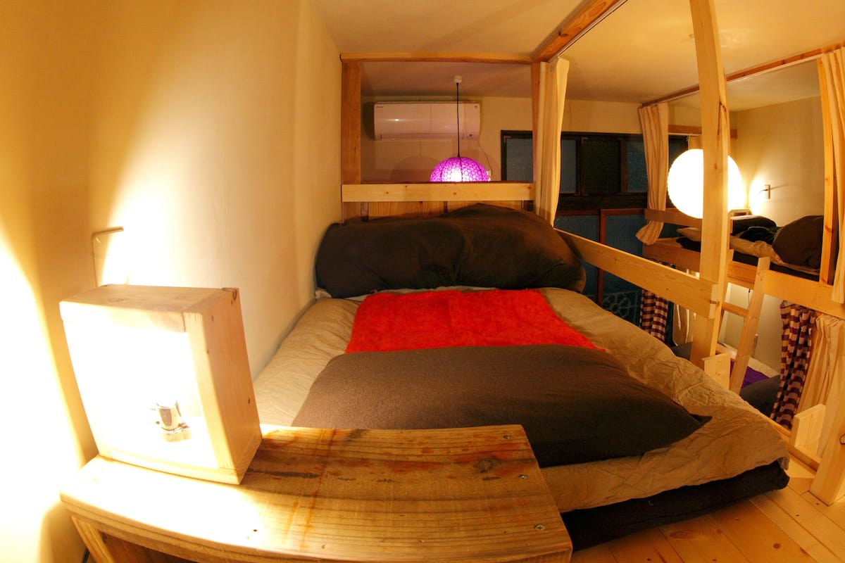 Une petite chambre comprenant un lit, un bureau et un miroir.