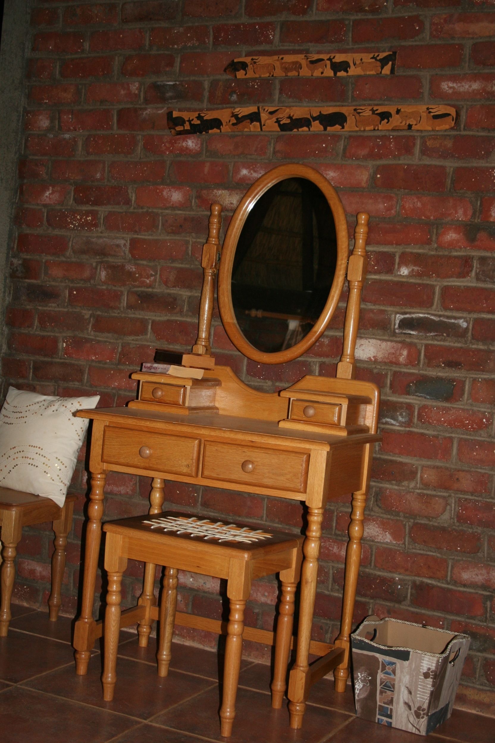 Un meuble en bois fixé au mur, doté d’un miroir, un petit tabouret en bois et une paire de skis appuyés contre le mur.