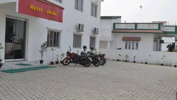 A hotel named 'Hotel Josh' with a paved driveway and parked motorcycles.