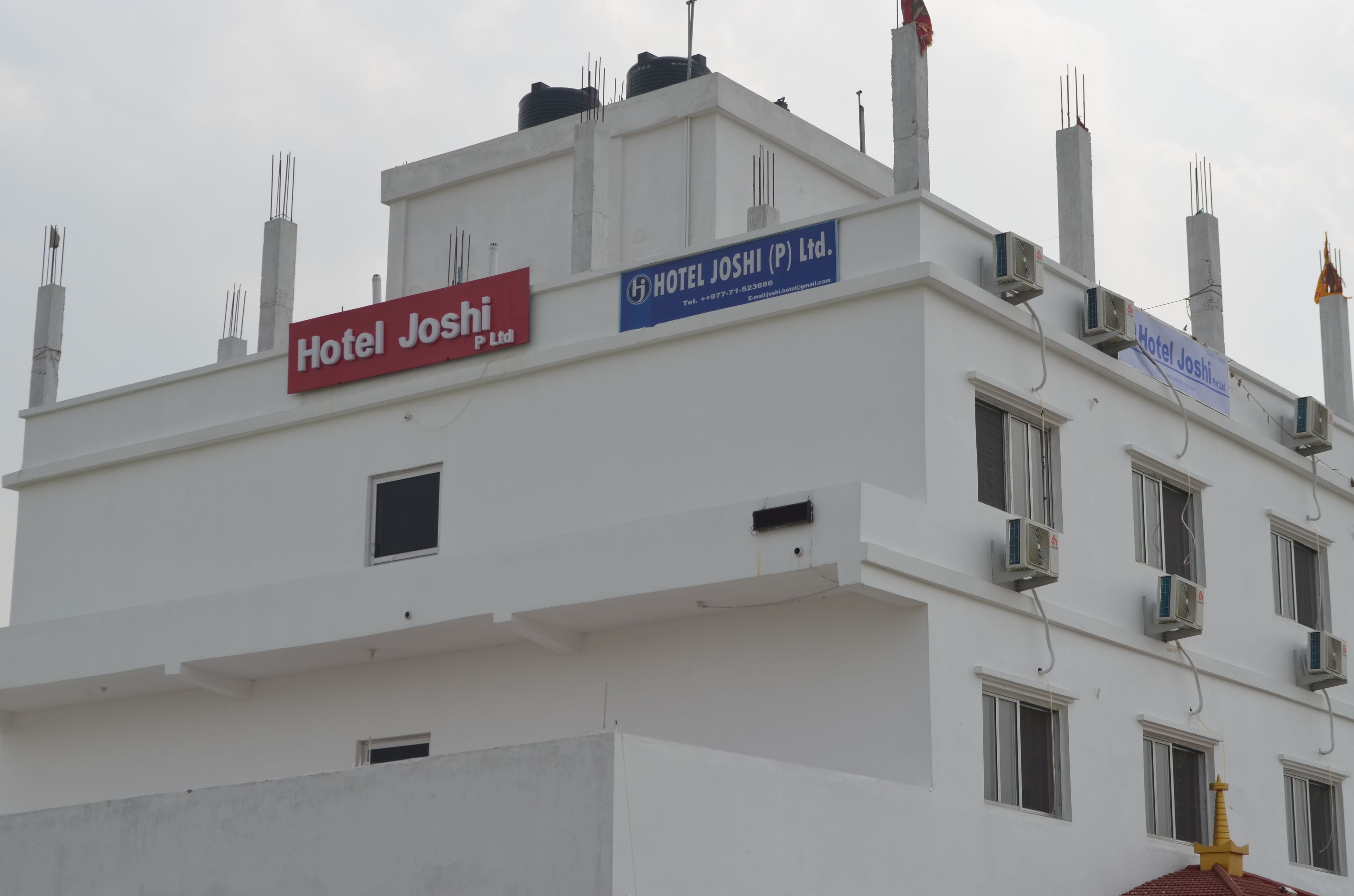 Un edificio con letreros que indican Hotel Joshi (P) Ltd. y Hotel Joshi (P) Ltd.
