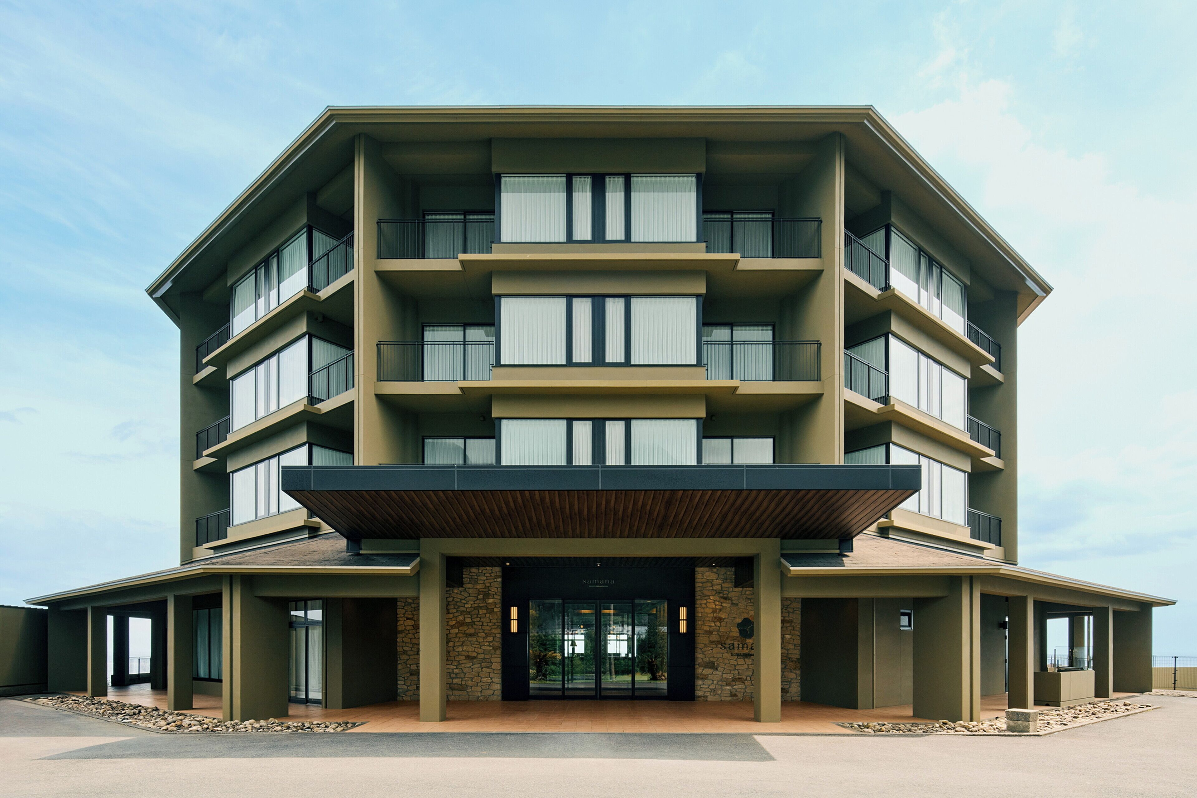 Un hôtel à plusieurs étages, doté d’un toit plat, de grandes fenêtres et d’une façade en pierre.