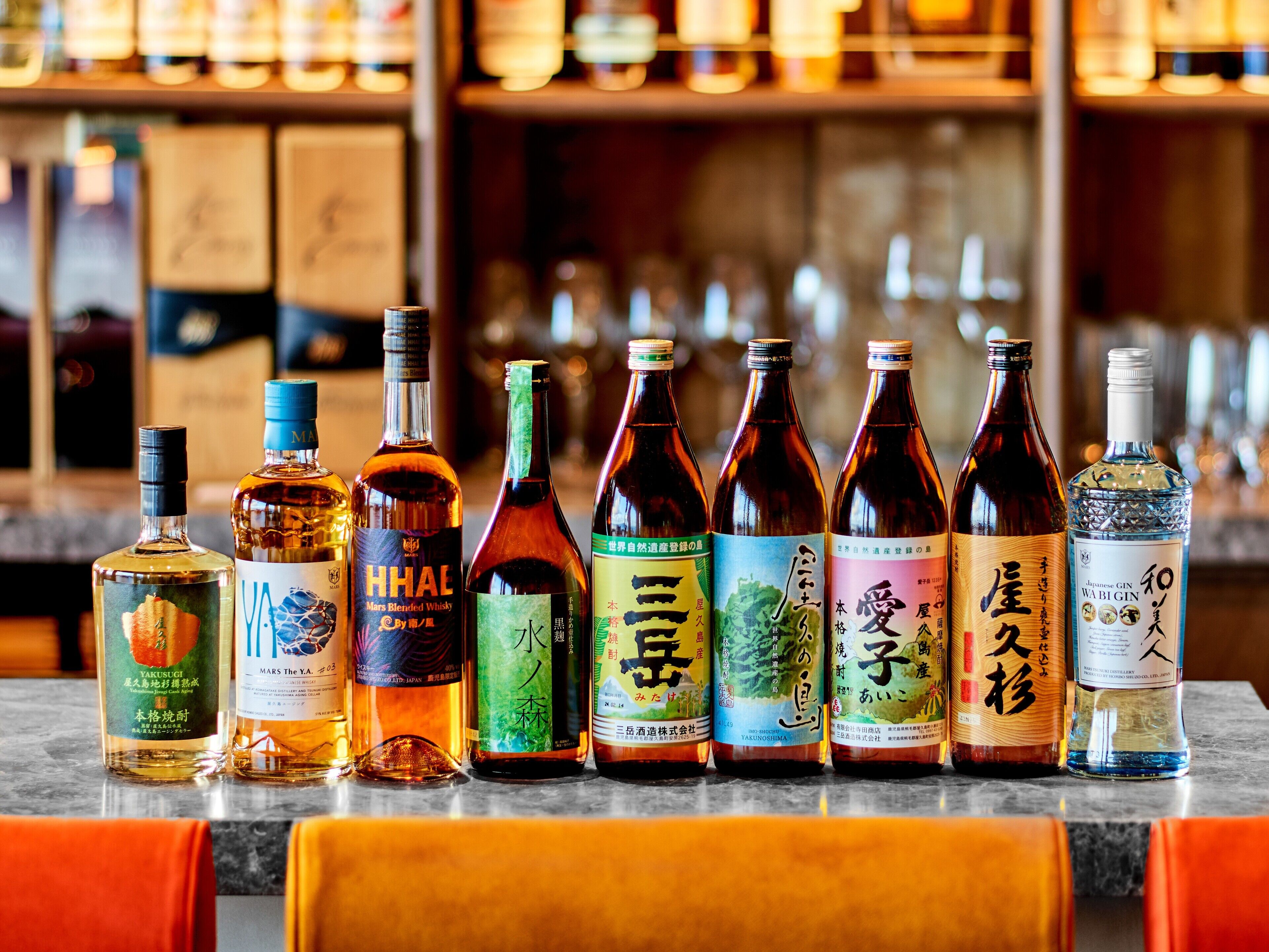 A row of various bottles of alcohol on a bar counter.