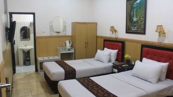 A hotel room with two beds, a bathroom, a wardrobe, and a painting on the wall.