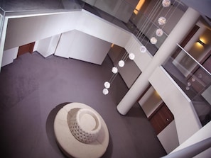 Relax in a serene space with a central seating area, spherical decorations, and a staircase leading to an upper level.