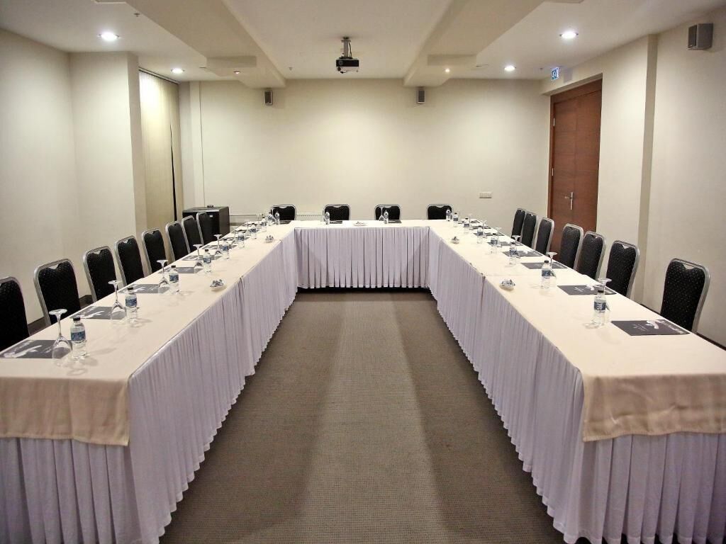Ein Konferenzraum mit einem langen Tisch, Stühlen und einem Projektor.