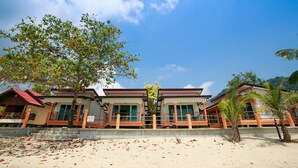 A beachfront hotel with a two-story structure, large windows, and a covered outdoor area. - Lamai Resort (Koh Samui)