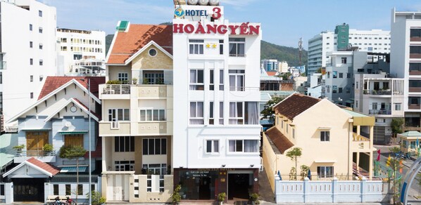 Hotel 3 Hoang Yen, a multi-story building with a prominent sign, balconies, and a modern architectural style.