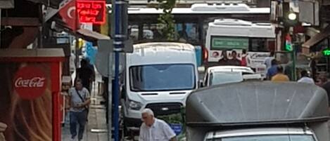 A busy street with parked cars, a Coca-Cola advertisement, and a sign for a Turkish restaurant.