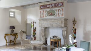 A spacious room with a fireplace, ornate furniture, and a decorative ceiling mural. - Le Manoir de la Fieffe (Cherbourg-en-Cotentin)