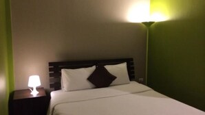 A hotel room with a bed, a nightstand, and two wall-mounted lamps. - Baan Chomphu (Prachuap Khiri Khan)
