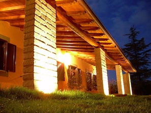 A building with a brick exterior and a wooden pergola structure. - Agriturismo Bella Cima (Montefiascone)