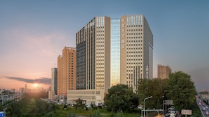 Een hoog gebouw met meerdere verdiepingen, grote ramen en een opvallende ingang.