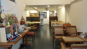 A cozy café with wooden furniture, a chalkboard menu, and various decorative items. - The Commonroom CNX (Chiang Mai)