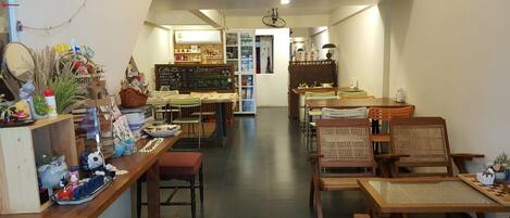 A cozy café with wooden furniture, a chalkboard menu, and various decorative items.