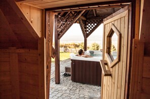 Une cabane en bois avec un jacuzzi et une vue sur le paysage.
