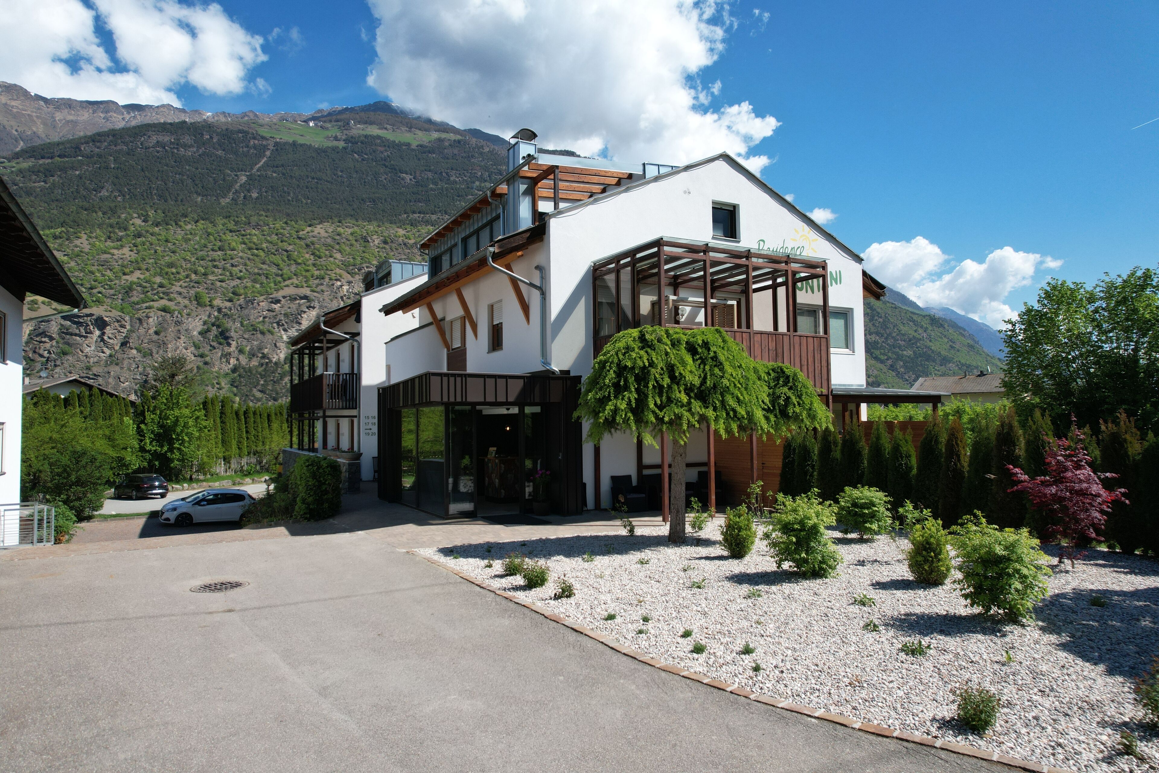 A two-story building with a modern design, featuring a balcony and a large window.