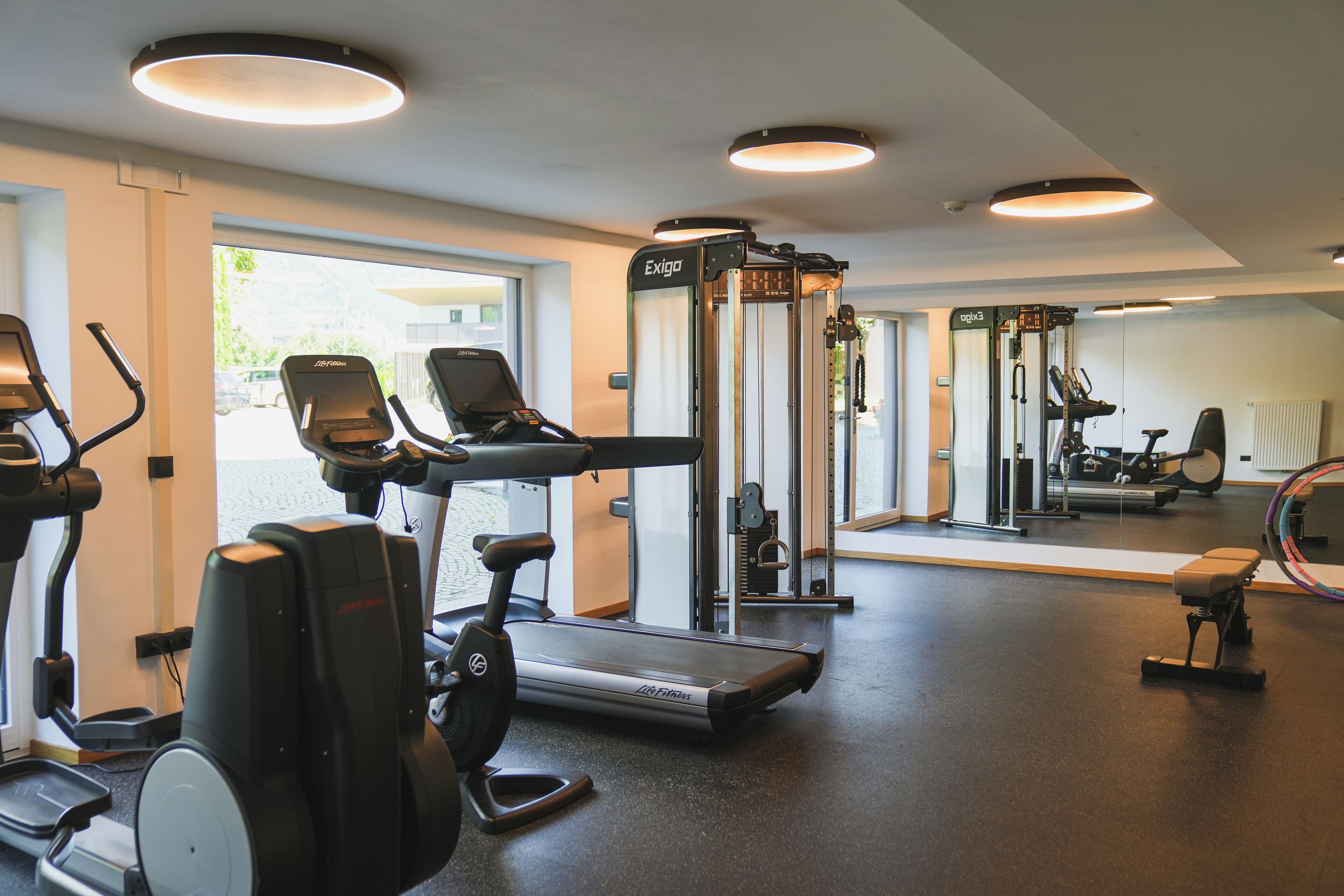 A gym with treadmills, elliptical machines, and a weight machine.