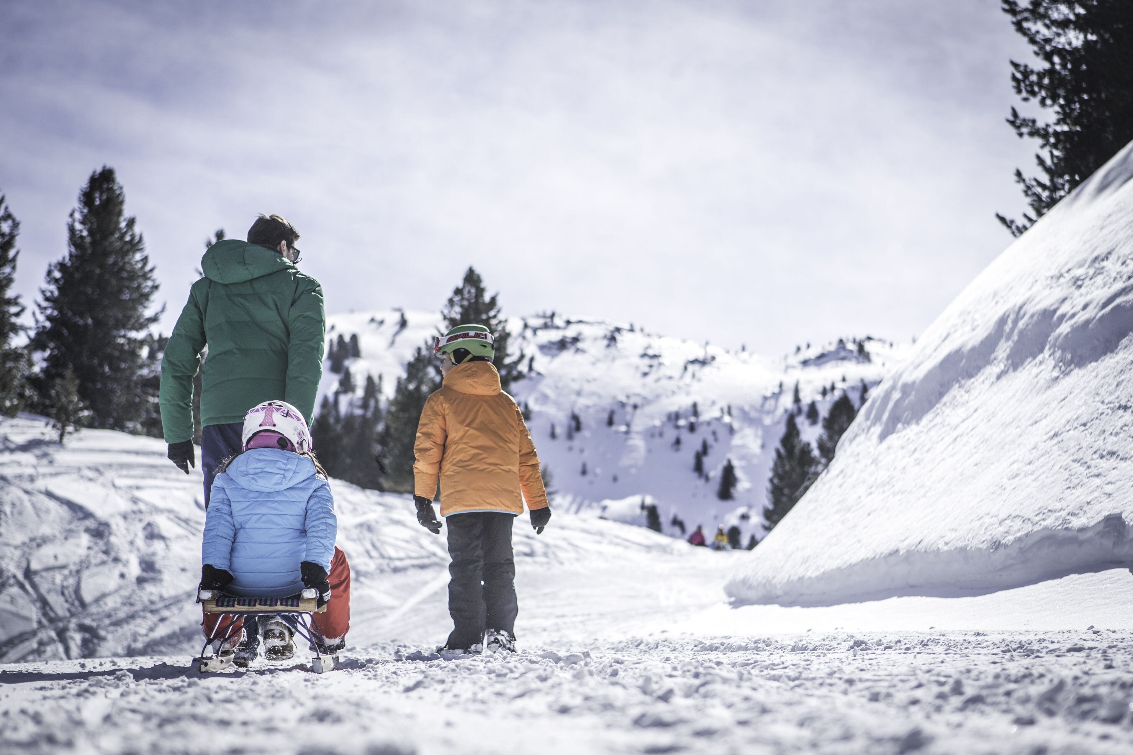A snowy mountain slope with people skiing and snowboarding.