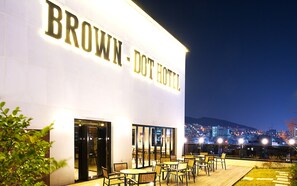 The exterior of the Brown Dot Hotel with outdoor seating and a city view. - Brown Dot Busan Station Sky Garden (Busan)