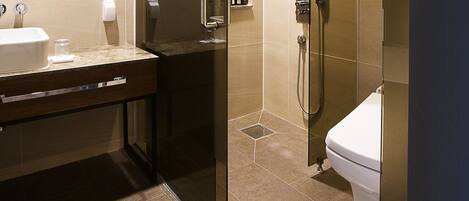 A modern bathroom with a glass-enclosed shower, a sink, and a toilet.