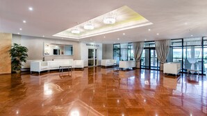 A spacious lobby with a polished tile floor, a reception desk, and seating areas. - Hotel La Mar (Kielce)