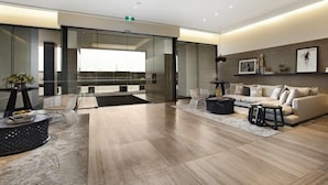 A modern living room with a sofa set, a coffee table, and a glass partition. - Melbourne Docklands Concavo Seaview Apartment (Docklands)
