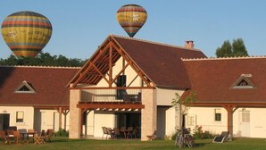 Een gebouw met twee verdiepingen, een overdekt terras en een balkon.