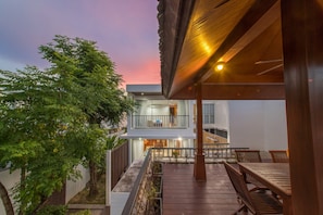A modern two-story house with a balcony and outdoor seating area.