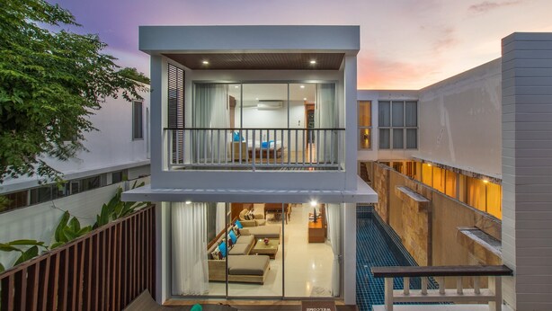 A modern two-story hotel with a balcony, a pool, and a well-lit interior. - Private Villa with Pool near Laguna (Choeng Thale)