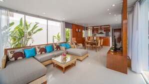 A modern living room with a sofa set, a coffee table, and a dining area. - Private Villa with Pool near Laguna (Choeng Thale)