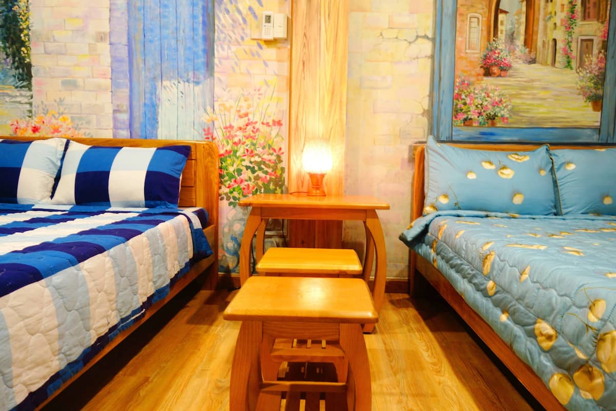 A cozy room with two beds, a wooden bench, and a small table.