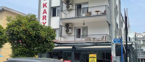 A multi-story building with balconies and air conditioning units.
