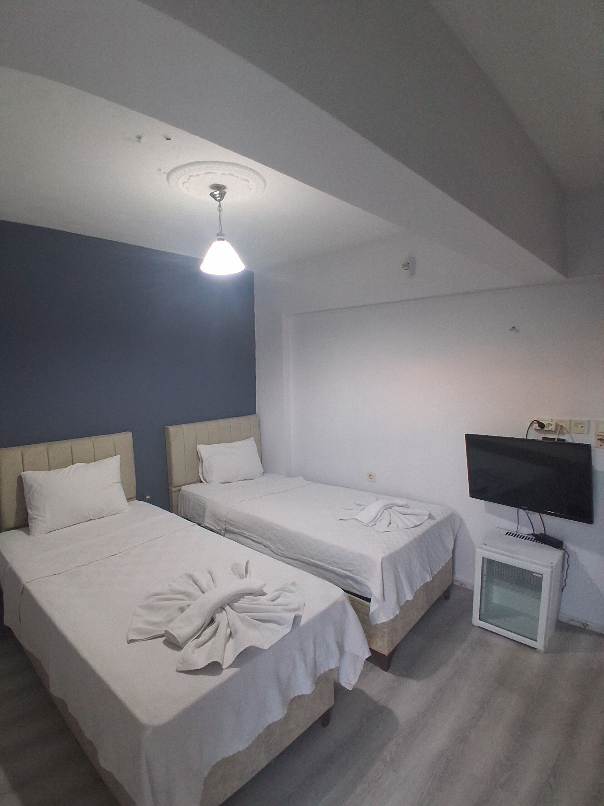 Una habitación de hotel con dos camas, un televisor y una mesita.