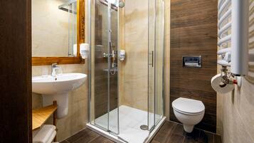 A modern bathroom with a glass-enclosed shower, a sink, and a toilet.