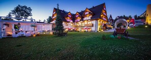 Ein großes, mehrstöckiges Gebäude im traditionellen Baustil, mit Balkonen und einer gut beleuchteten Fassade.