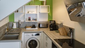 Una cocina compacta equipada con lavadora, tostadora y cafetera.