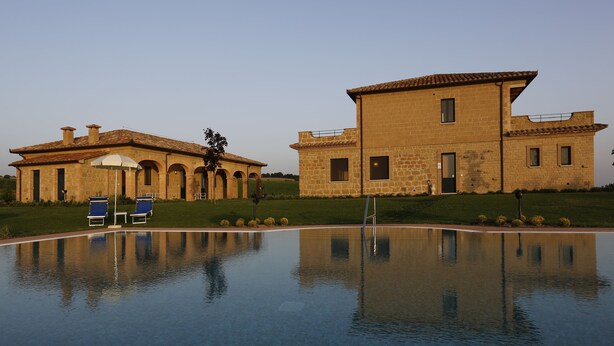 A large building with a swimming pool in front.