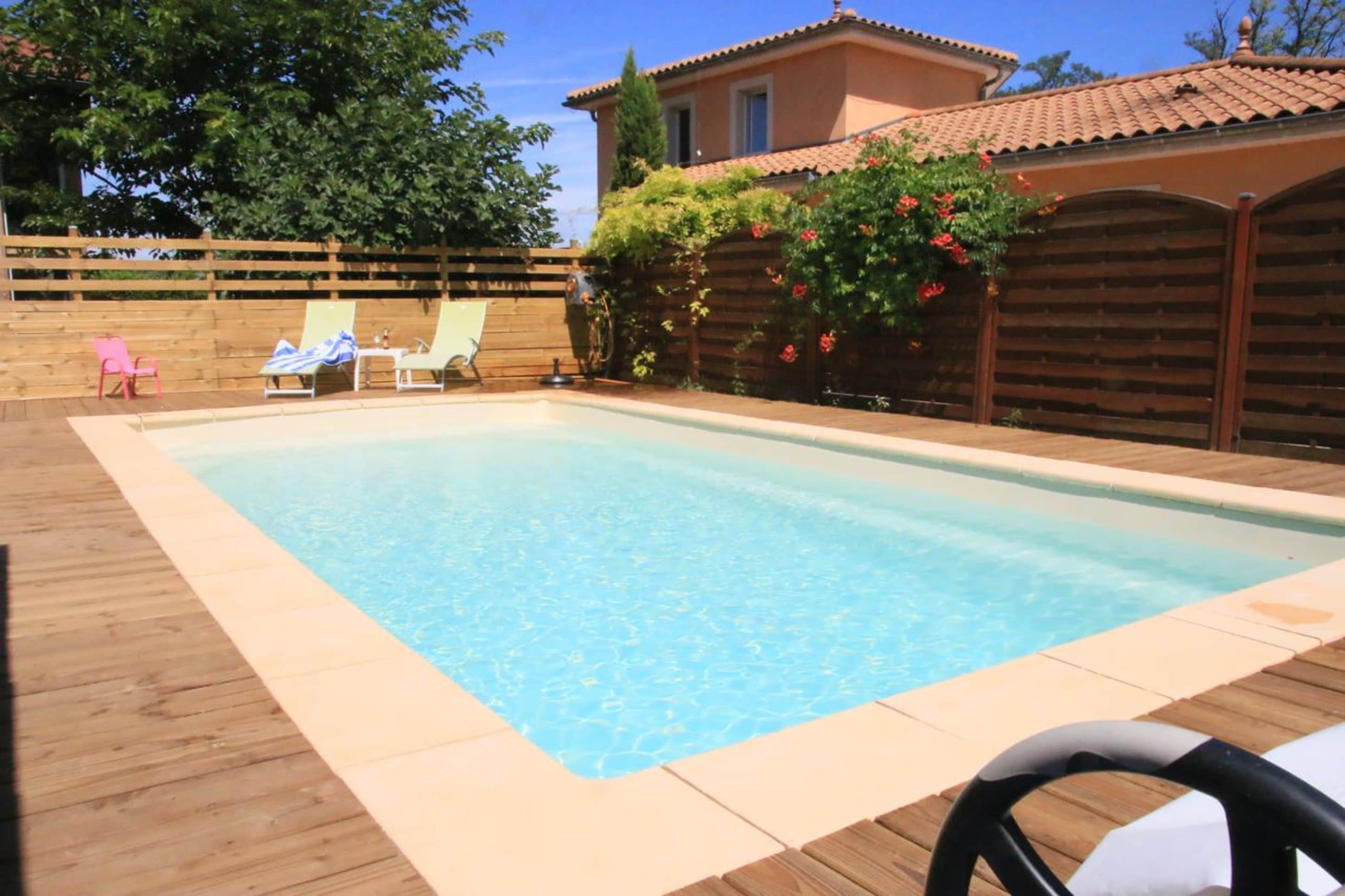 Una piscina al aire libre, sillones reclinables de piscina