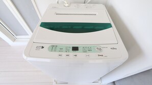 Um aparelho branco e compacto fixado na parede, com visor digital e botões de comando.