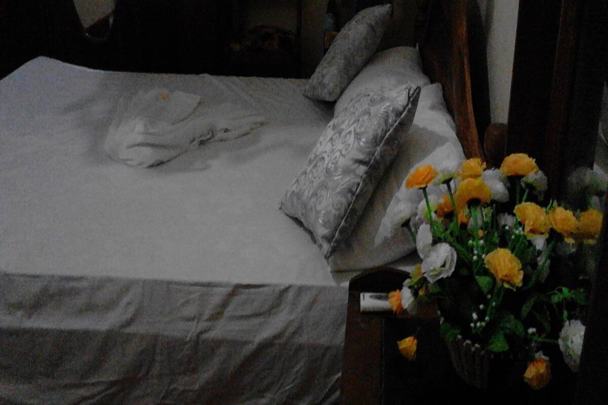 A bed with pillows and a bouquet of flowers.