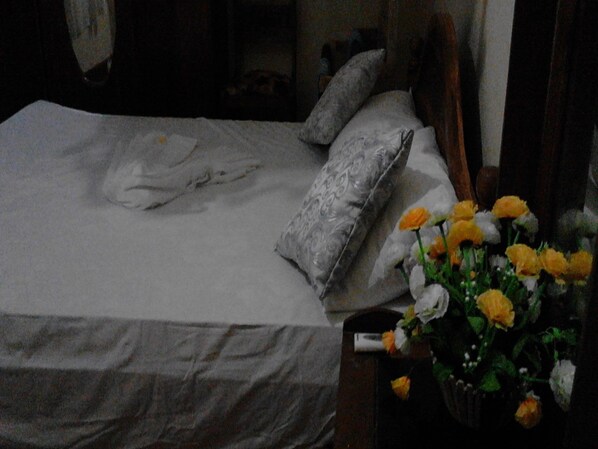 A bed with pillows and a bouquet of flowers. - Sigiriya Vee Guest (Sigiriya)