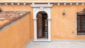 A building with a tiled roof, a doorway with an arch, and a tiled floor. - Charming Palace Corte Del Teatro (Venice)