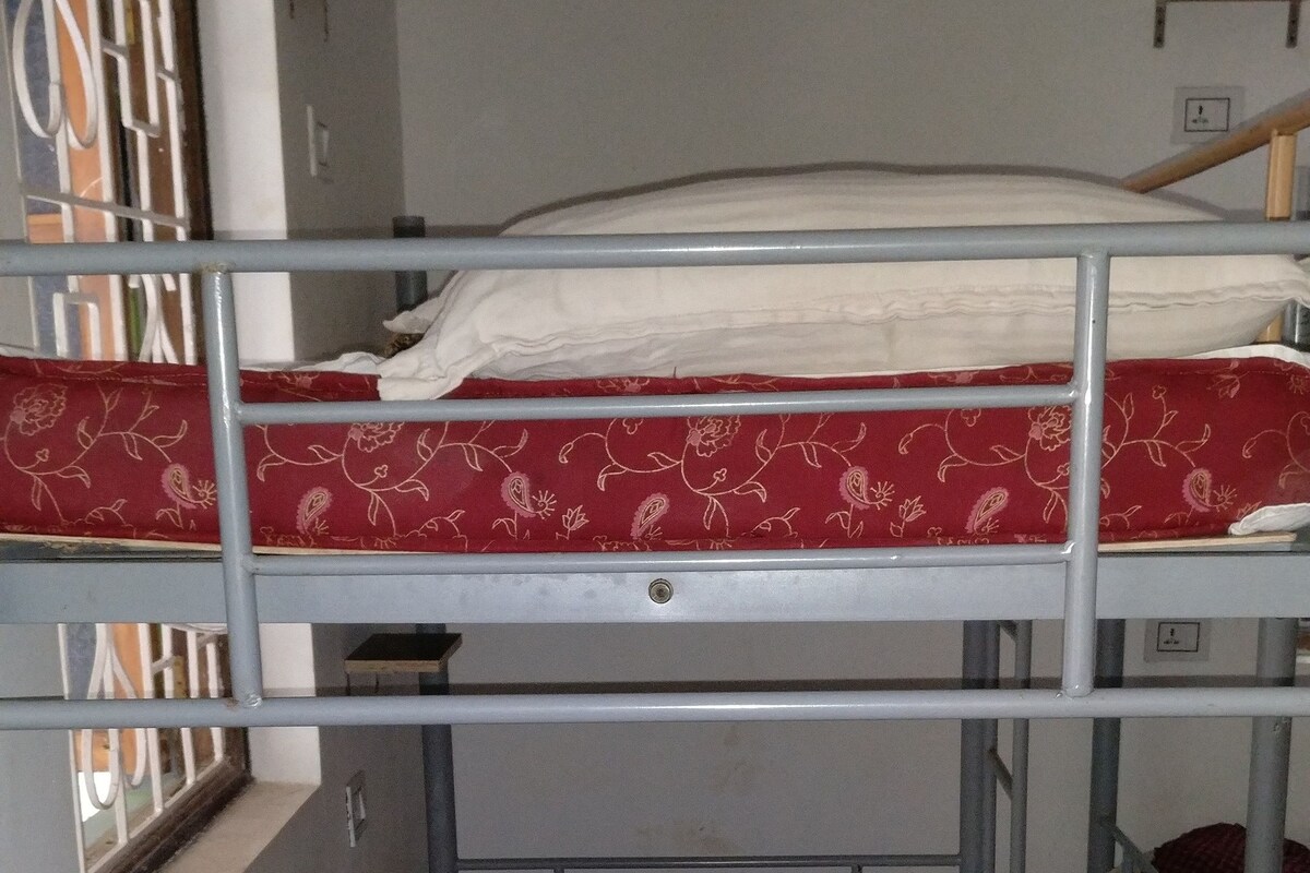 Un dormitorio con literas, una ventana y una puerta.