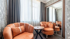 A modern room with a large mirror, orange upholstered chairs, and a round wooden table. - 216 Macity (Istanbul)