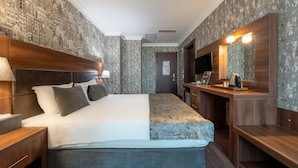 A hotel room with a bed, bedside table, lamp, and a mirror with a light. - 216 Macity (Istanbul)