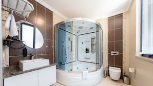A modern bathroom with a glass-enclosed shower, a vanity with a sink, and a toilet. - 216 Macity (Istanbul)