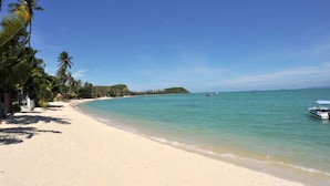 A beach with clear turquoise water, a sandy shore, and a few boats. - 5BR Beachfront Villa Bangrak (Koh Samui)