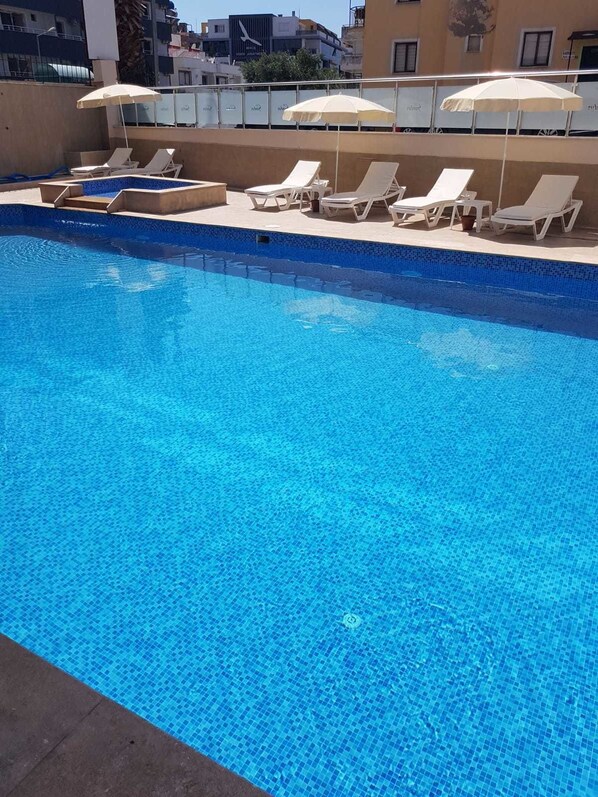 Outdoor pool, open 8:00 AM to 7:00 PM, pool umbrellas, pool loungers